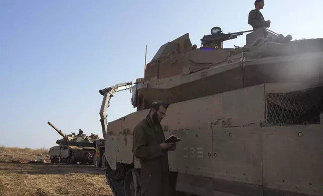 Israeli soldiers pray at a staging area in northern Israel, Sunday, Oct. 6, 2024. (AP Photo/Baz Ratner)