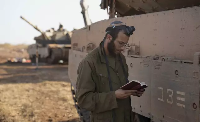 An Israeli soldier prays at a staging area in northern Israel, Sunday, Oct. 6, 2024. (AP Photo/Baz Ratner)