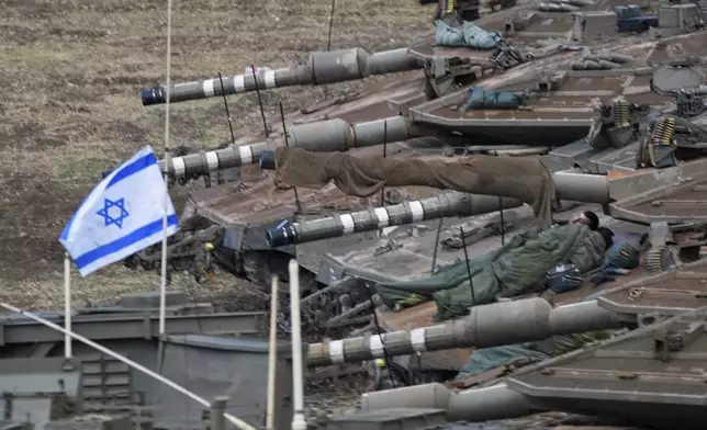 Israeli soldiers sleep on tanks in a staging area in northern Israel near the Israel-Lebanon border, Tuesday, Oct. 1, 2024. (AP Photo/Baz Ratner)