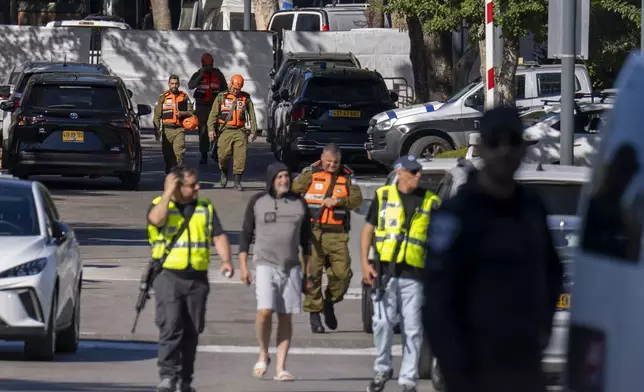 Officers from the Israeli Home Front Command military unit walk on a road near where Israel's government says a drone launched toward Israeli Prime Minister Benjamin Netanyahu's house in Caesarea, Israel, Saturday, Oct. 19, 2024. (AP Photo/Ariel Schalit)