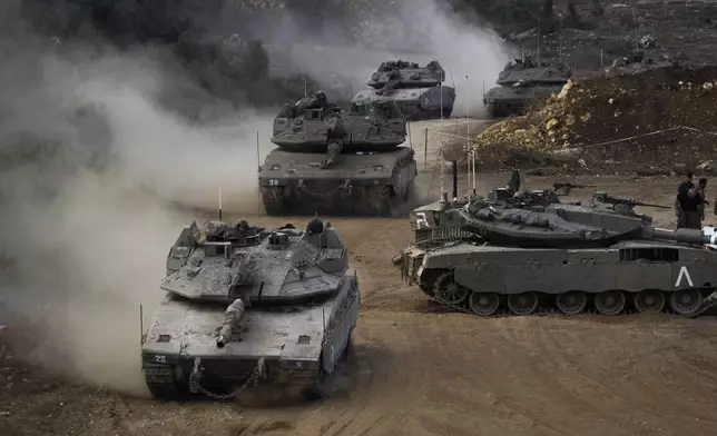 Israeli army tanks manoeuvre in a staging area in northern Israel near the Israel-Lebanon border, Tuesday, Oct. 1, 2024. (AP Photo/Baz Ratner)