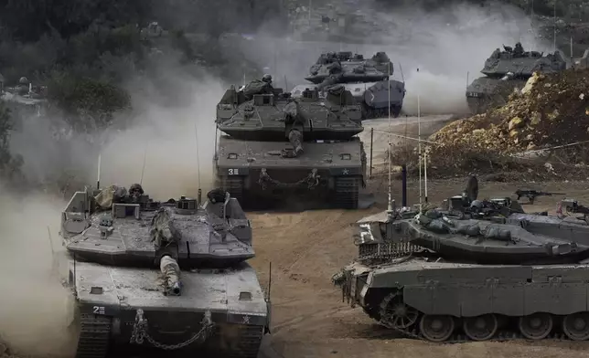 Israeli army tanks manoeuvre in a staging area in northern Israel near the Israel-Lebanon border, Tuesday, Oct. 1, 2024. (AP Photo/Baz Ratner)