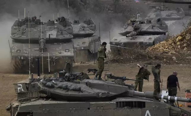 Israeli army tanks manoeuvre in a staging area in northern Israel near the Israel-Lebanon border, Tuesday, Oct. 1, 2024. (AP Photo/Baz Ratner)