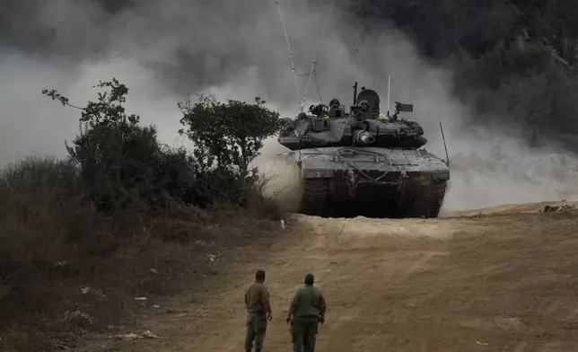 Israeli army tanks manoeuvre in a staging area in northern Israel near the Israel-Lebanon border, Tuesday, Oct. 1, 2024. (AP Photo/Baz Ratner)