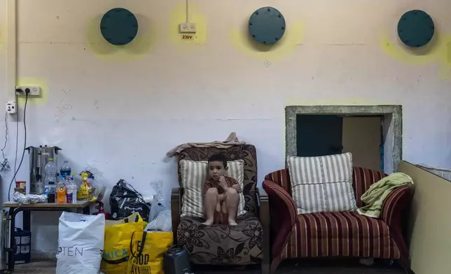 A boy sits in a public bomb shelter to be safe from rockets fired from Lebanon in Acre, northern Israel, Sunday, Oct. 13, 2024. (AP Photo/Ariel Schalit)