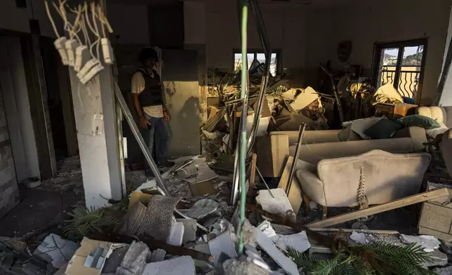 An Israeli security forces officer examines the damage to a home struck by a rocket fired from Lebanon in the town of Majd al-Krum, northern Israel, Wednesday, Oct. 16, 2024. (AP Photo/Ariel Schalit)