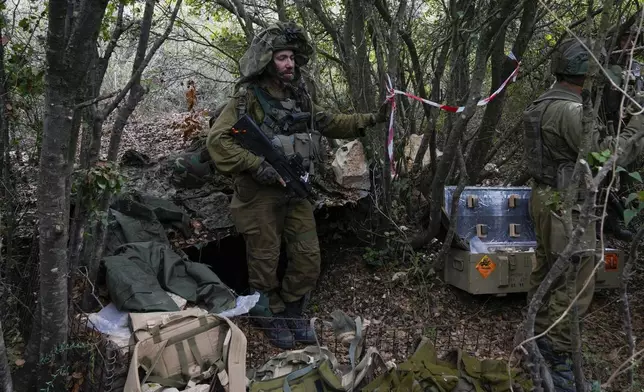 Israeli soldiers display what they say are Hezbollah ammunition and explosives found during their ground operation in southern Lebanon, near the border with Israel, Sunday, Oct. 13, 2024. (AP Photo/Sam McNeil)