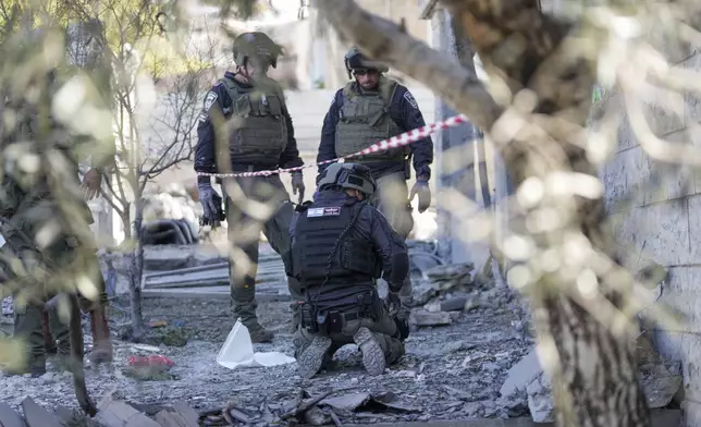 Members of the Israeli police bomb squad work at the site where one person was killed after a projectile launched from Lebanon slammed into Maalot-Tarshiha, northern Israel, Tuesday, Oct. 29, 2024. (AP Photo/Ohad Zwigenberg)