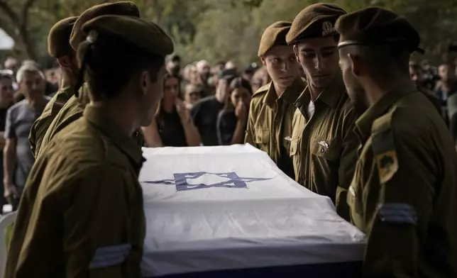 Israeli soldiers carry the flagged-covered coffin of Sgt. Amitai Alon, killed by a Hezbollah drone attack, during his funeral near Ramot Naftali, Israel, Monday, Oct. 14, 2024. (AP Photo/Leo Correa)