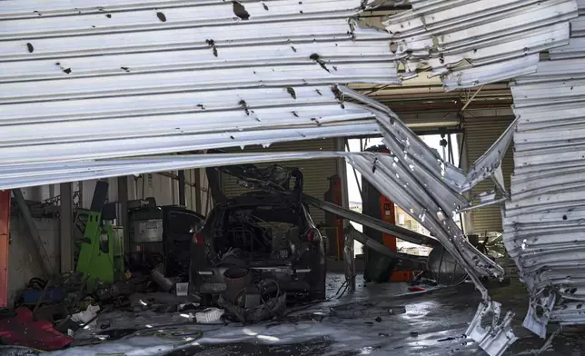 A damaged is seen inside a car repair shop that was hit by a rocket fired from Lebanon in Kiryat Shmona, northern Israel, Friday, Oct. 4, 2024. (AP Photo/Leo Correa)