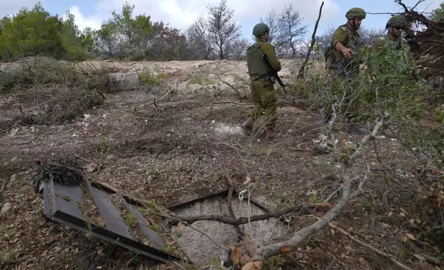 Israeli soldiers display what they say is an entrance to a Hezbollah tunnel found during their ground operation in southern Lebanon, near the border with Israel, Sunday, Oct. 13, 2024. (AP Photo/Sam McNeil)