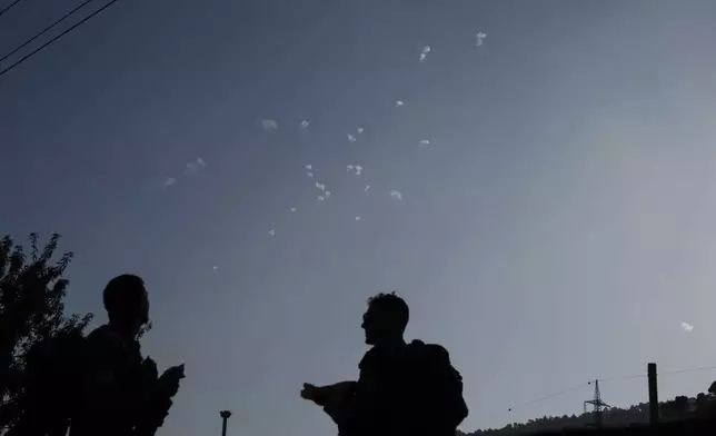 Members of the Israeli forces watch the Iron Dome air defense system firing to intercept rockets that were launched from Lebanon, in northern Israel, Wednesday, Oct. 9, 2024. (AP Photo/Leo Correa)