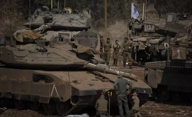 FILE - Israeli soldiers work on tanks and armoured personnel carriers (APC) in northern Israel, on Sept. 30, 2024. (AP Photo/Leo Correa, File)