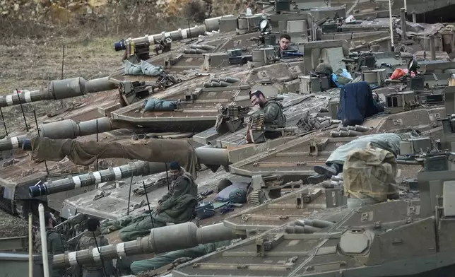 FILE - Israeli soldiers work on tanks in a staging area in northern Israel near the Israel-Lebanon border, on Oct. 1, 2024. (AP Photo/Baz Ratner, File)