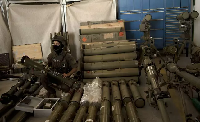 An Israeli soldier from an EOD (explosive ordnance disposal) poses with a weapon used by Hezbollah seized during combat operations in Lebanon displayed during a government-organized media tour on a base in southern Israel, Wednesday, Oct. 9, 2024. (AP Photo/Maya Alleruzzo)