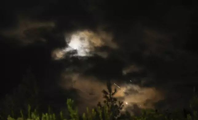 Projectiles fly through the sky in central Israel as a siren sounds a warning of incoming missiles fired from Iran towards Israel, Tuesday, Oct. 1, 2024. (AP Photo/Ohad Zwigenberg)