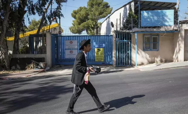 An ultra-Orthodox Jewish man walks past the east Jerusalem compound of UNRWA, the U.N. agency helping Palestinian refugees, Tuesday, Oct. 29, 2024. (AP Photo/Mahmoud Illean)