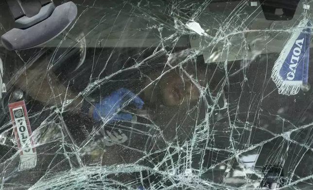 An Israeli police officer inspects inside the cabin of a truck that rammed into a bus stop near the headquarters of Israel's Mossad spy agency, wounding dozens of people, according to Israel's Magen David Adom rescue service in Tel Aviv, Israel, Sunday, Oct. 27, 2024. (AP Photo/Oded Balilty)