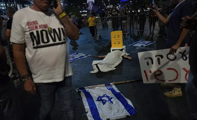 People take part in a performance during a protest against Israel Prime Minister Benjamin Netanyahu's government and call for the release of hostages held in the Gaza Strip by the Hamas militant group, in Tel Aviv, Israel, Saturday, Oct. 5, 2024. (AP Photo/Ariel Schalit)