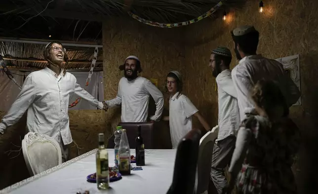 Israelis celebrate the news of the death of Hamas leader Yahya Sinwar, near Kibbutz Erez, southern Israel, on Thursday, Oct. 17, 2024, (AP Photo/Tsafrir Abayov)