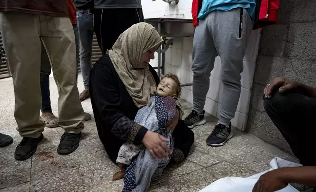 A Palestinian woman mourns a child killed in the Israeli bombardment of the Gaza Strip at a hospital morgue in Deir al-Balah, Wednesday, Oct. 2, 2024. (AP Photo/Abdel Kareem Hana)