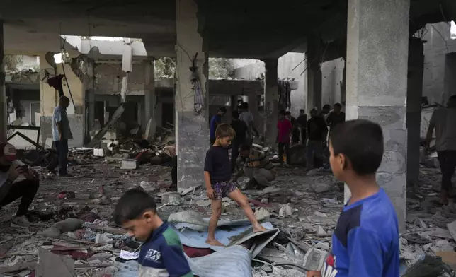 Palestinians examine a destroyed mosque following an Israeli airstrike in Deir al-Balah, Sunday, Oct. 6, 2024. (AP Photo/Abdel Kareem Hana)