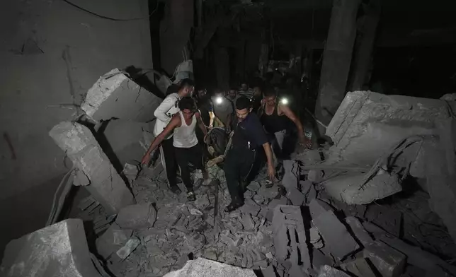 Palestinians carry the body of a person who was found under the rubble of a destroyed mosque following an Israeli airstrike in Deir al-Balah, Sunday, Oct. 6, 2024. (AP Photo/Abdel Kareem Hana)