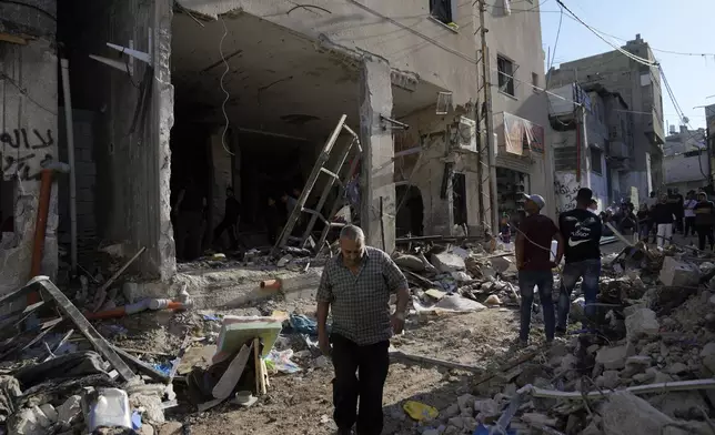 Palestinians examine the damage following an Israeli airstrike in the West Bank city of Tulkarem, which Palestinian health officials say killed 18 people and the Israeli military says took out a Hamas leader, on Friday, Oct. 4, 2024. (AP Photo/Nasser Nasser)