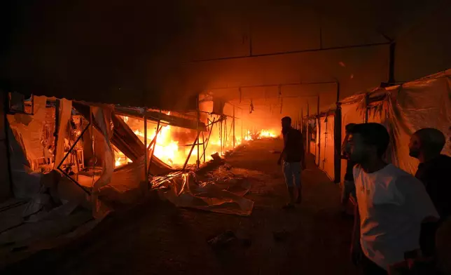 Palestinians react to a fire after an Israeli strike hit a tent area in the courtyard of Al Aqsa Martyrs hospital in Deir al Balah, Gaza Strip, Monday, Oct. 14, 2024. (AP Photo/Abdel Kareem Hana)