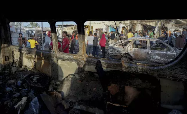 Palestinians look at the damage after an Israeli strike hit a tent area in the courtyard of Al Aqsa Martyrs hospital in Deir al Balah, Gaza Strip, Monday, Oct. 14, 2024. (AP Photo/Abdel Kareem Hana)