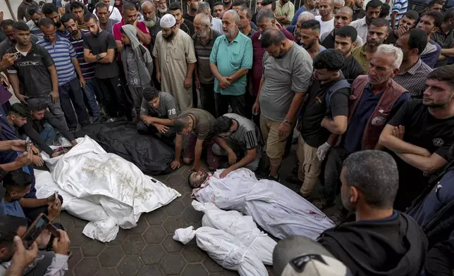 Palestinians mourn their relatives killed in the Israeli bombardment of the Gaza Strip at a hospital in Deir al-Balah, Tuesday, Oct. 8, 2024. (AP Photo/Abdel Kareem Hana)