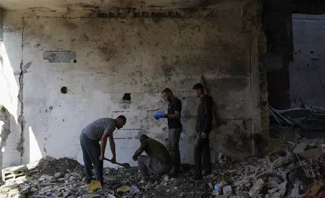 Palestinians examine the damage following an Israeli airstrike in the West Bank city of Tulkarem, which Palestinian health officials say killed 18 people and the Israeli military says took out a Hamas leader, on Friday, Oct. 4, 2024. (AP Photo/Nasser Nasser)