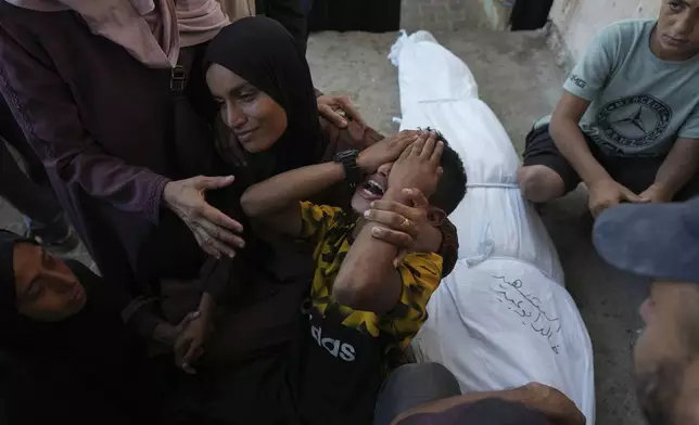 Mourners attend the funeral of Palestinians killed in the Israeli bombardment of the Gaza Strip outside the hospital morgue in Deir al-Balah on Wednesday, Oct. 9, 2024. (AP Photo/Abdel Kareem Hana)