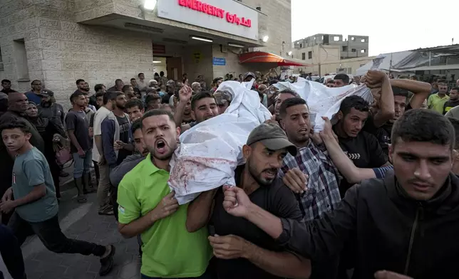 Palestinians mourn as they carry the bodies of relatives killed in the Israeli bombardment of the Gaza Strip at a hospital in Deir el-Balah, Sunday, Oct. 20, 2024. (AP Photo/Abdel Kareem Hana)