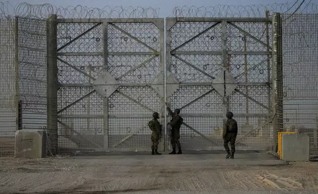 Israeli soldiers close the gate of Erez Crossing after trucks carrying humanitarian aid entered the Gaza Strip, in southern Israel, Monday, Oct. 21, 2024. (AP Photo/Tsafrir Abayov)