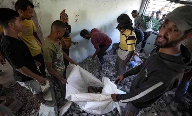 Palestinians search for the remains of their relatives killed in an Israeli bombardment of a school in Deir al-Balah, central Gaza Strip, Thursday, Oct. 10, 2024. (AP Photo/Abdel Kareem Hana)