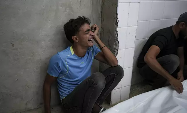 A young Palestinian mourns his relatives killed in the Israeli bombardment of the Gaza Strip at a hospital in Deir el-Balah, Sunday, Oct. 20, 2024. (AP Photo/Abdel Kareem Hana)