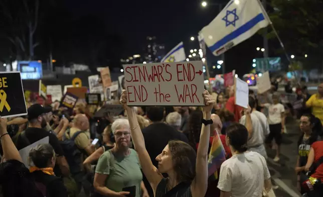 A demonstrator holds a sign about the killing of Hamas leader Yahya Sinwar during a protest calling for a cease-fire deal and the immediate release of hostages held by Hamas on Thursday, Oct. 17, 2024, in Tel Aviv, Israel. (AP Photo/Ariel Schalit)