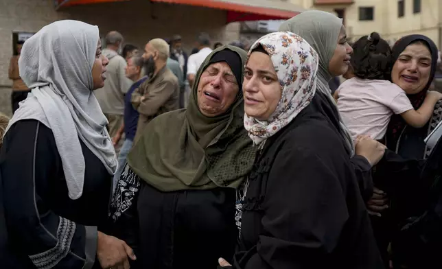 Palestinians mourn their relatives killed in the Israeli bombardment of the Gaza Strip at a hospital in Deir al-Balah, Tuesday, Oct. 8, 2024. (AP Photo/Abdel Kareem Hana)