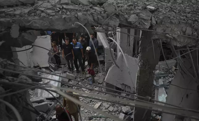 Palestinians examine a destroyed mosque following an Israeli airstrike in Deir al-Balah, Sunday, Oct. 6, 2024. (AP Photo/Abdel Kareem Hana)