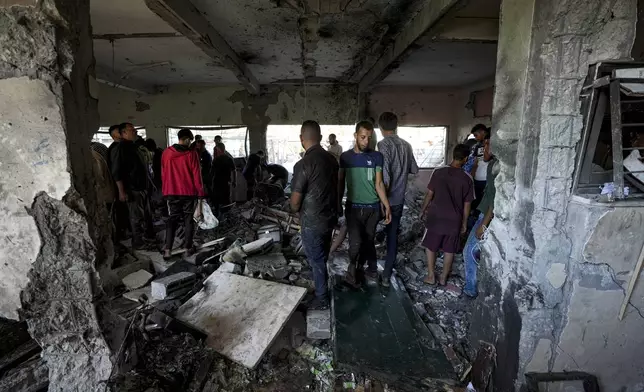 Palestinians search for the bodies of their relatives killed in an Israeli bombardment of a school in Deir al-Balah, central Gaza Strip, Thursday, Oct. 10, 2024. (AP Photo/Abdel Kareem Hana)