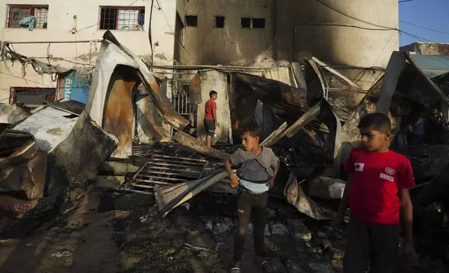 Palestinians look at the damage after an Israeli strike hit a tent area in the courtyard of Al Aqsa Martyrs hospital in Deir al Balah, Gaza Strip, Monday, Oct. 14, 2024. (AP Photo/Abdel Kareem Hana)