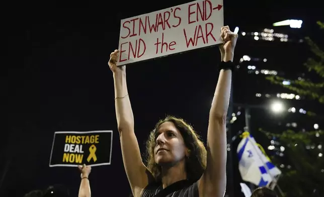 A demonstrator holds a sign about the killing of Hamas leader Yahya Sinwar during a protest calling for a cease-fire deal and the immediate release of hostages held by Hamas on Thursday, Oct. 17, 2024, in Tel Aviv, Israel. (AP Photo/Ariel Schalit)