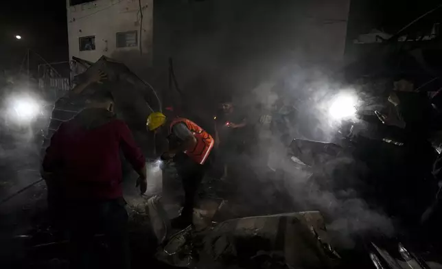 Palestinian firefighters try to extinguish a fire caused by an Israeli strike that hit a tent area in the courtyard of Al Aqsa Martyrs hospital in Deir al Balah, Gaza Strip, Monday, Oct. 14, 2024. (AP Photo/Abdel Kareem Hana)