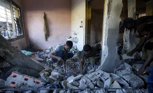 Palestinians search for the remains of their relatives killed in an Israeli bombardment of a school in Deir al-Balah, central Gaza Strip, Thursday, Oct. 10, 2024. (AP Photo/Abdel Kareem Hana)