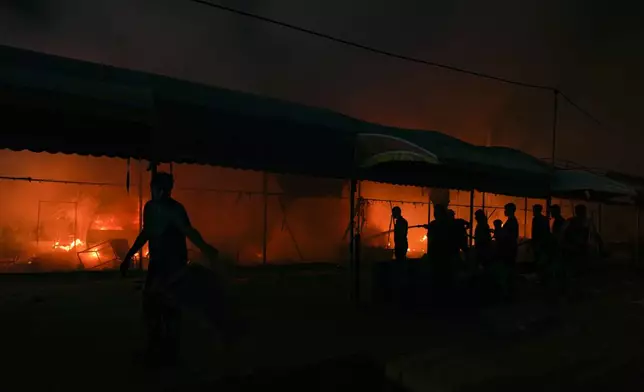 Palestinians try to extinguish a fire caused by an Israeli strike that hit a tent area in the courtyard of Al Aqsa Martyrs hospital in Deir al Balah, Gaza Strip, Monday, Oct. 14, 2024. (AP Photo/Abdel Kareem Hana)