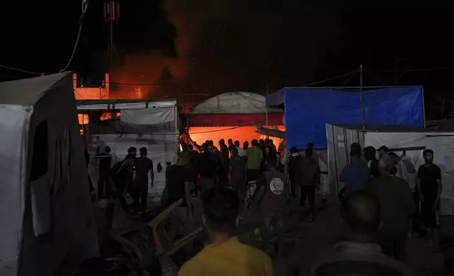 Palestinians react to a fire after an Israeli strike hit a tent area in the courtyard of Al Aqsa Martyrs hospital in Deir al Balah, Gaza Strip, Monday, Oct. 14, 2024. (AP Photo/Abdel Kareem Hana)