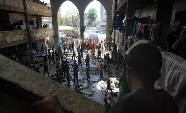 Palestinians inspect the damage of a school hit by an Israeli bombardment on Deir al-Balah, central Gaza Strip, Thursday, Oct. 10, 2024. (AP Photo/Abdel Kareem Hana)