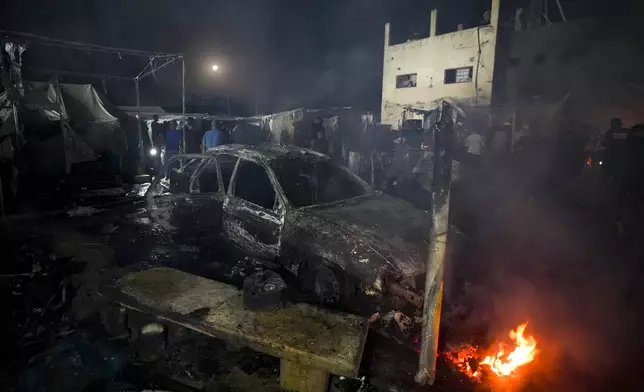 Palestinians inspect the damage at a tent area in the courtyard of Al Aqsa Martyrs hospital, hit by an Israeli bombardment on Deir al-Balah, central Gaza Strip, Monday, Oct. 14, 2024. (AP Photo/Abdel Kareem Hana)