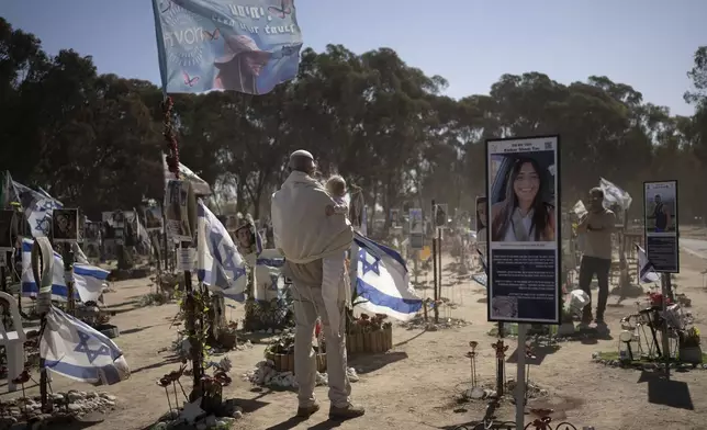 A man in prayer shawl visits the site of the Nova music festival, where hundreds of revelers were killed or kidnapped by Hamas, on the Jewish holiday of Simchat Torah, marking one year in the Hebrew calendar since the attack, near Kibbutz Re'im, southern Israel near the Gaza Strip, Thursday, Oct. 24, 2024. (AP Photo/Maya Alleruzzo)